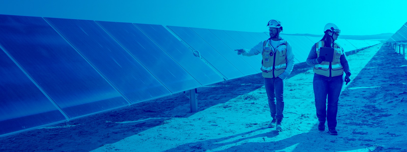 construction workers by solar panels blue overlay