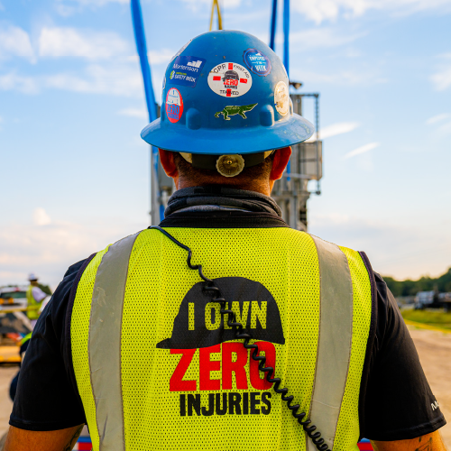 team member with Mortenson's "I Own Zero Injuries" logo on their safety vest
